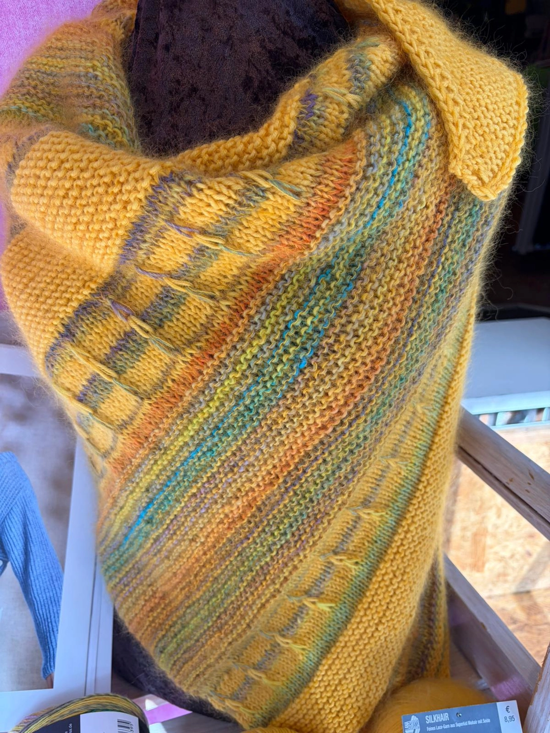 Mode & Handarbeitsdiele - Wolle, Kunsthandwerk, Mode und Accessoires - Gelber Schal: Nahaufnahme eines strukturierten, senfgelb-blau melierten Strickschals oder -tuchs.