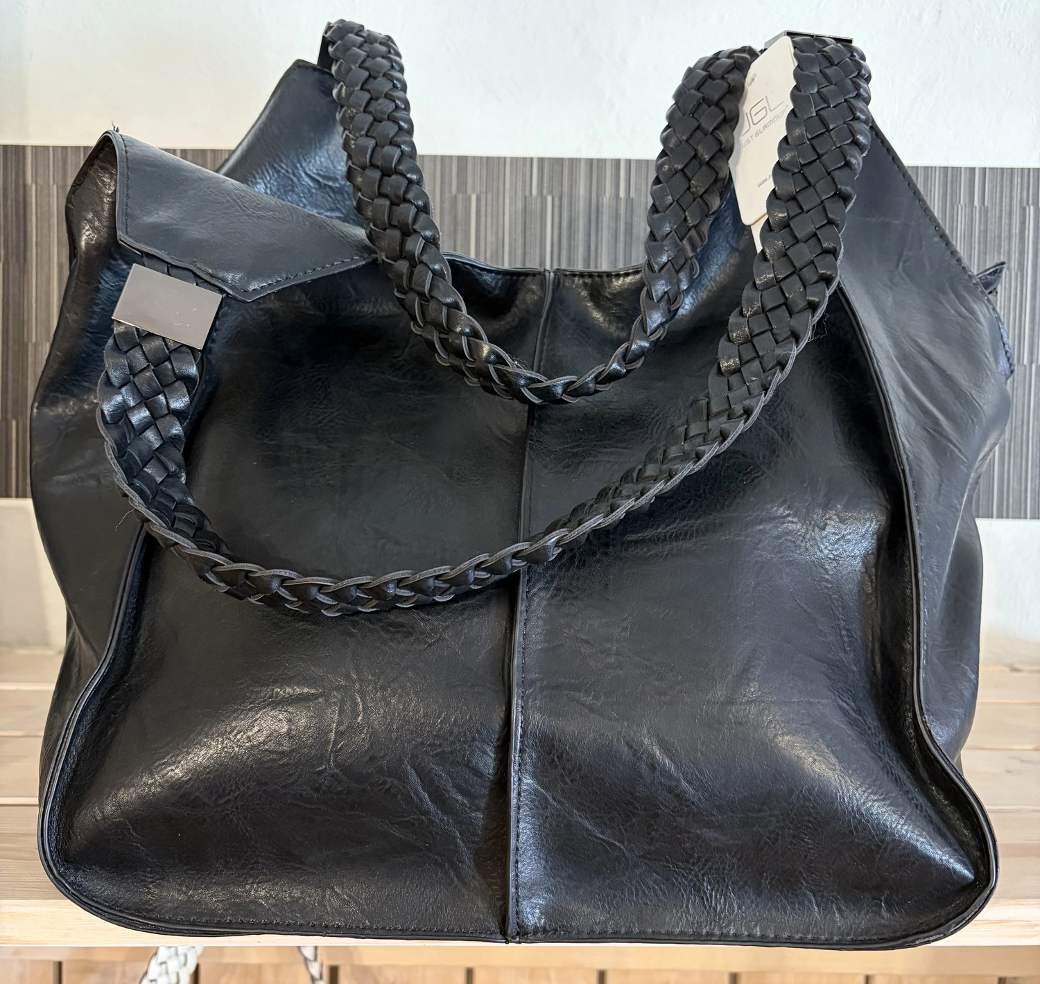 Mode & Handarbeitsdiele - Wolle, Kunsthandwerk, Mode und Accessoires - Eine große, lässige schwarze Ledertasche mit dicken, geflochtenen Schulterriemen.